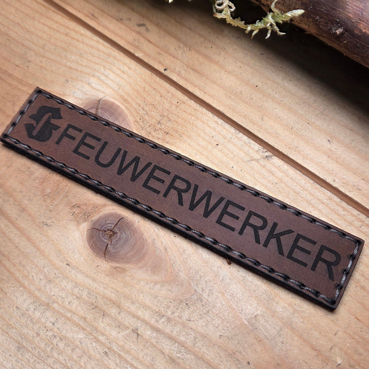 Namensband aus Leder in braun mit schwarzer Schrift 'FEUERWERKER', handvernäht und rechteckig mit Hakenklett-Rückseite
