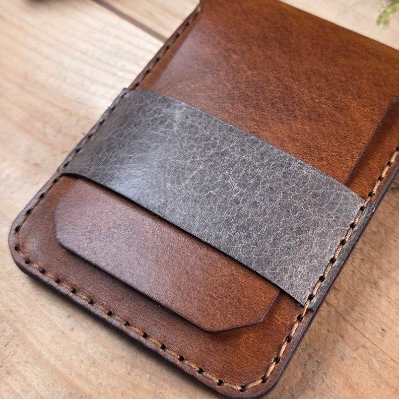 Slim Wallet aus Leder in braun mit grauem Lederriemen, handgefertigt mit sichtbaren Nähten und minimalistischem Design