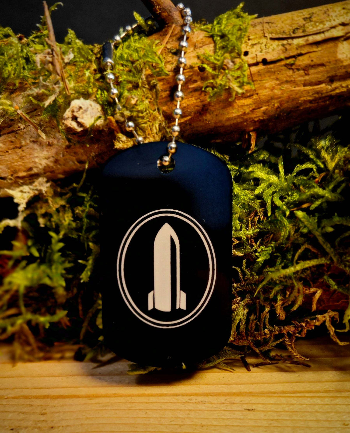 Anhänger Dog Tag aus schwarzer Aluminiumlegierung mit abgerundeten Kanten und Gravur eines Raketenmotivs