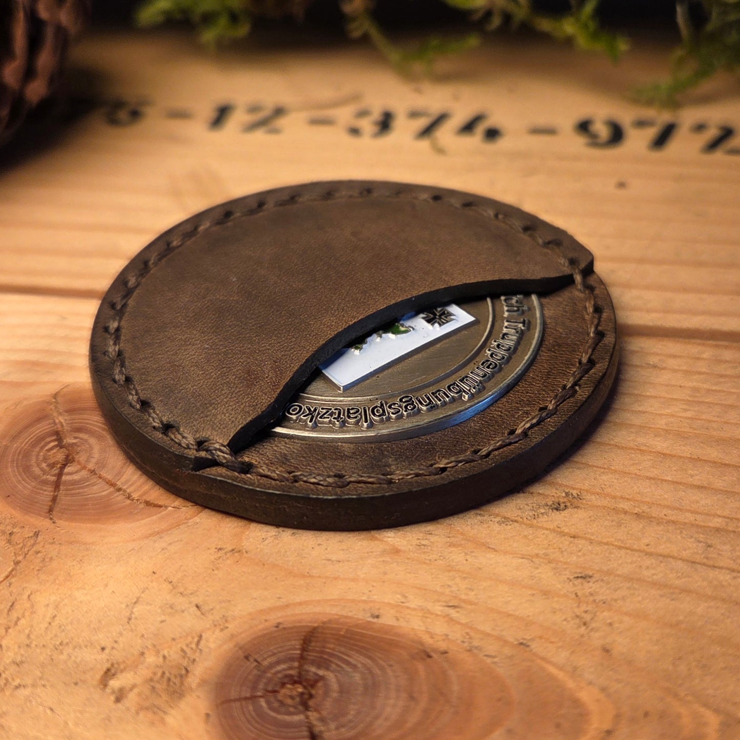 Handvernähte Coinhülle aus dunkelbraunem Vollnarbenleder mit sichtbarer Sattlernaht.