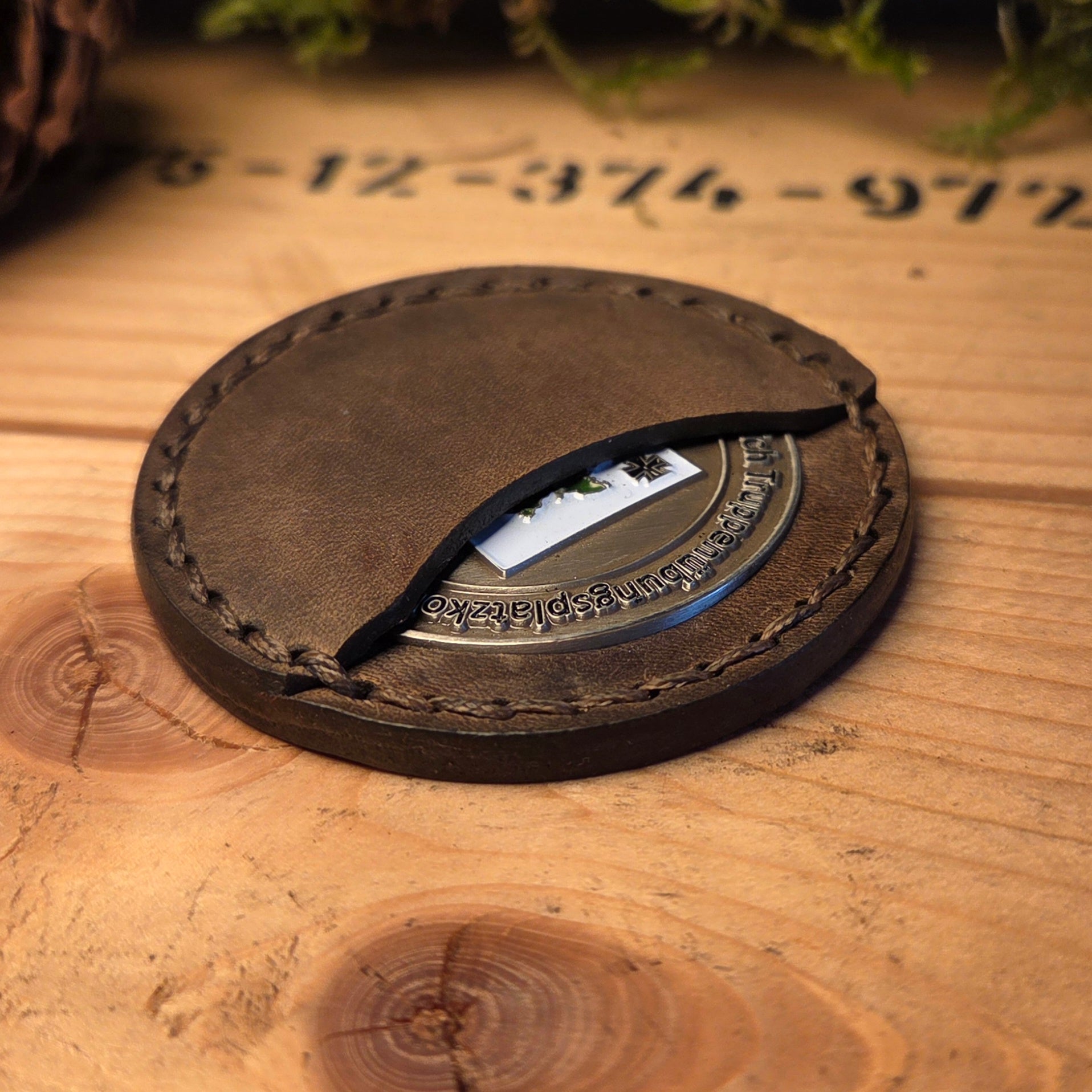 Handvernähte Coinhülle aus dunkelbraunem Vollnarbenleder mit sichtbarer Sattlernaht.