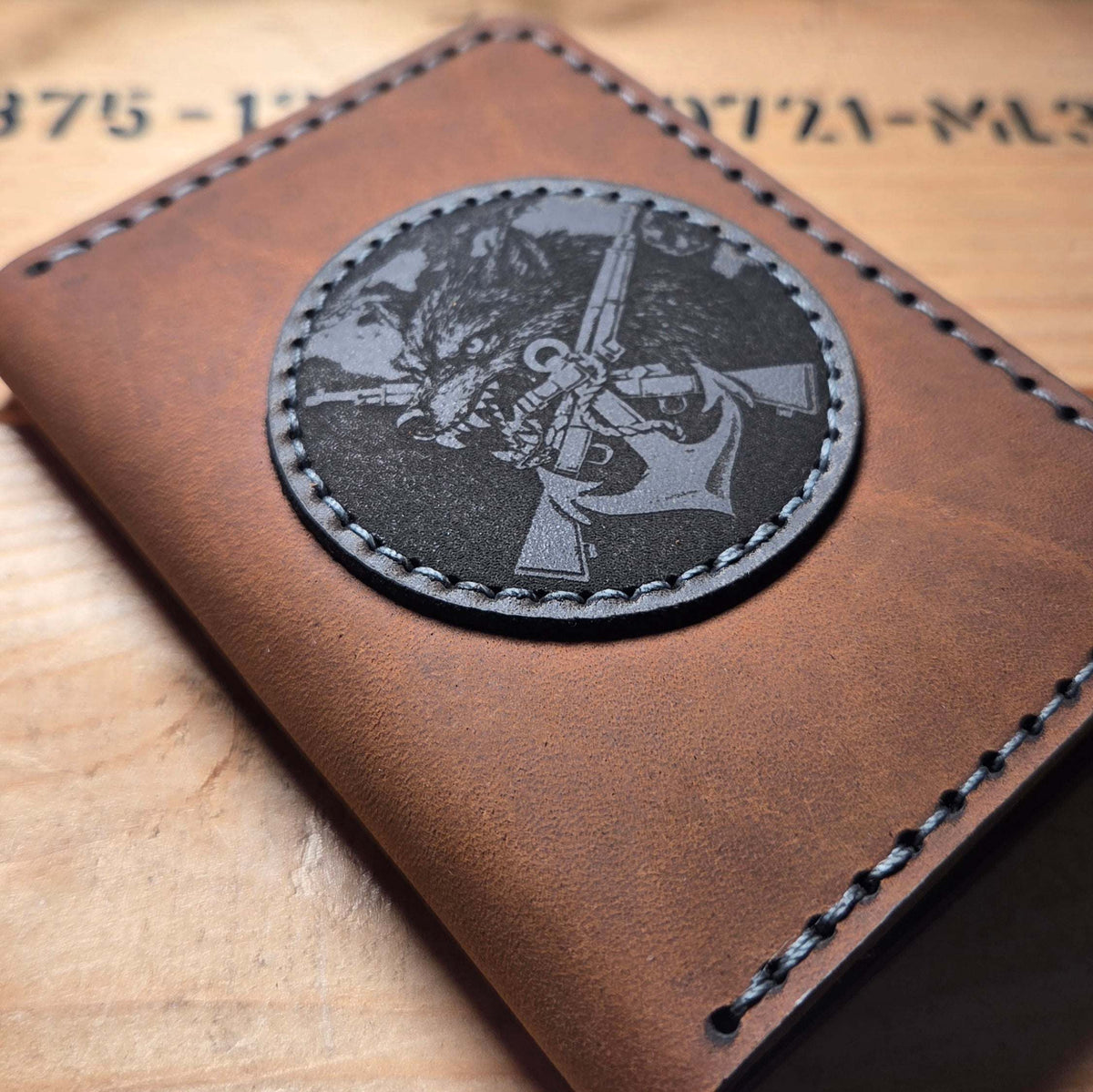 Dienstausweisetui aus Vollnarbenleder in braun mit handvernähter Naht und schwarzem Coinhalter mit Gravur eines Gewehrs