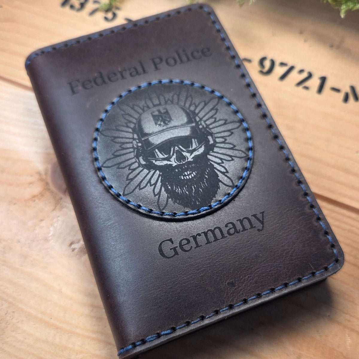 Dienstausweisetui aus Vollnarbenleder in dunkelbraun mit blauen Nähten und graviertem Emblem eines Totenschädels mit Helm