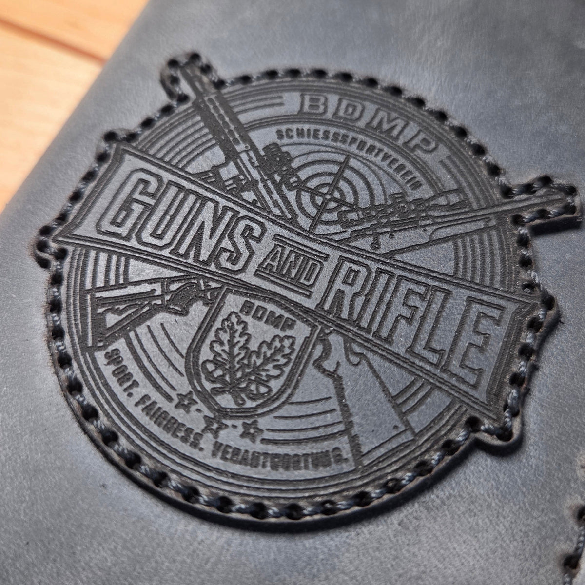 Dienstausweisetui aus Vollnarbenleder in dunkelgrau mit handvernähtem Rand und graviertem Motiv "Guns and Rifle" für Schiesssportverein