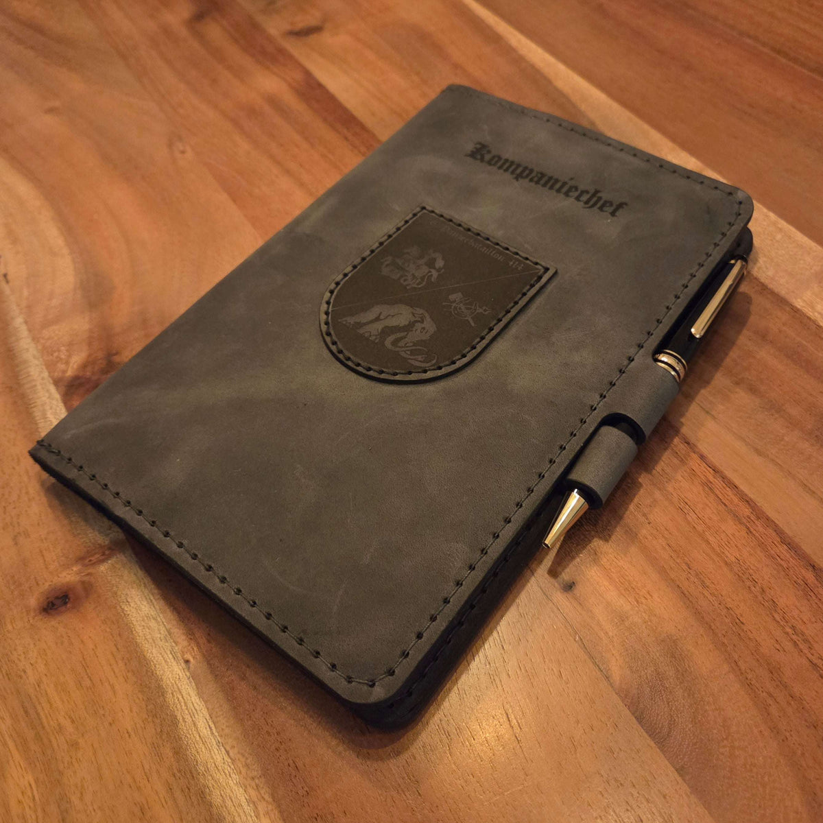 DIN A5 Organizer aus grauem Leder mit aufgenähtem Wappen und Lasergravur, inklusive integriertem Stiftehalter