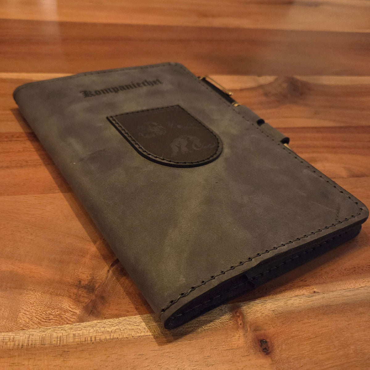 DIN A5 Organizer aus graubraunem Leder mit aufgenähtem Wappen, handgefertigt und mit integriertem Stiftehalter