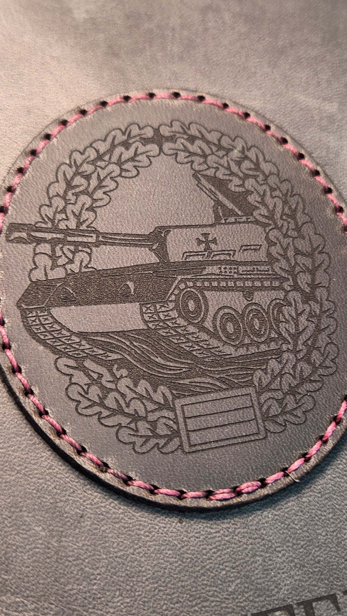 DIN A5 Organizer aus grauem Leder mit graviertem Panzer-Motiv in Eichenlaubkranz, pinke Zierstiche um das Motiv