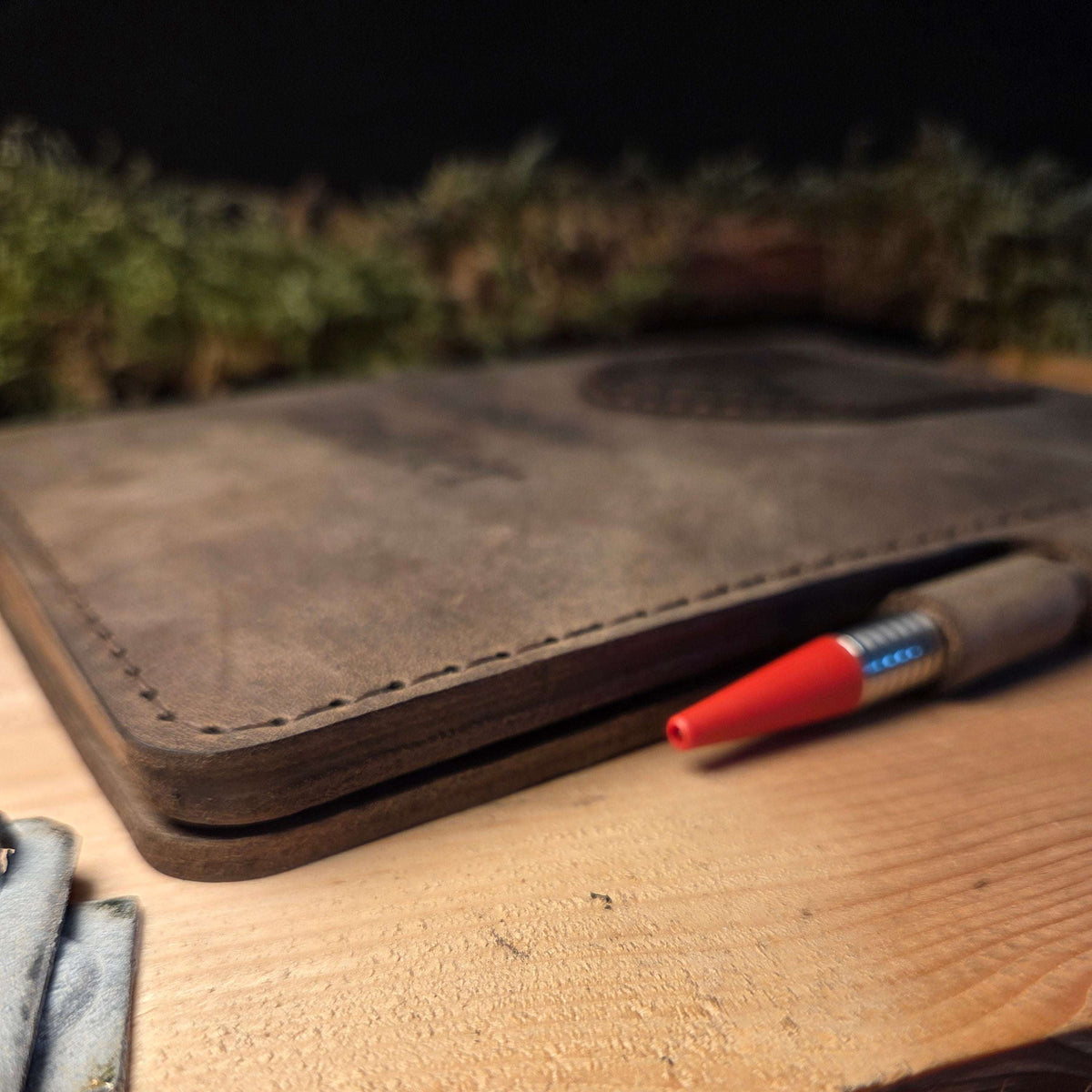 Handgefertigter DIN A5 Organizer aus braunem Leder mit sichtbarer Stichnaht und aufgenähtem Wappen, integriertem Stiftehalter