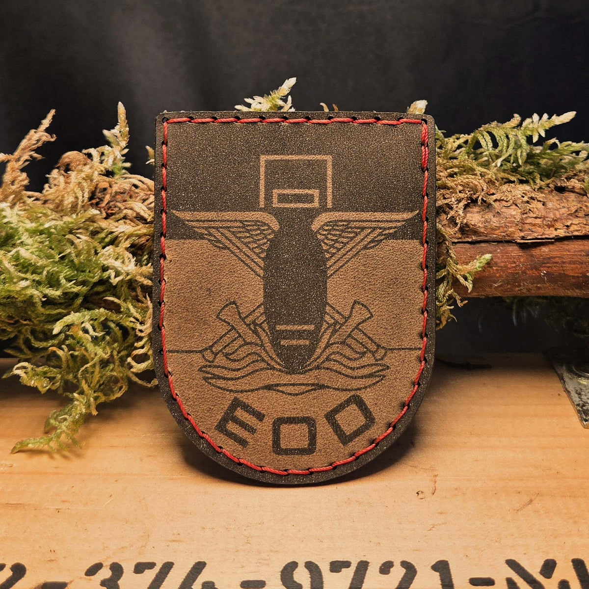 EOD Leder Patch aus braunem Echtleder mit roter Sattlernaht und graviertem EOD Symbol die Bombe mit Flügeln