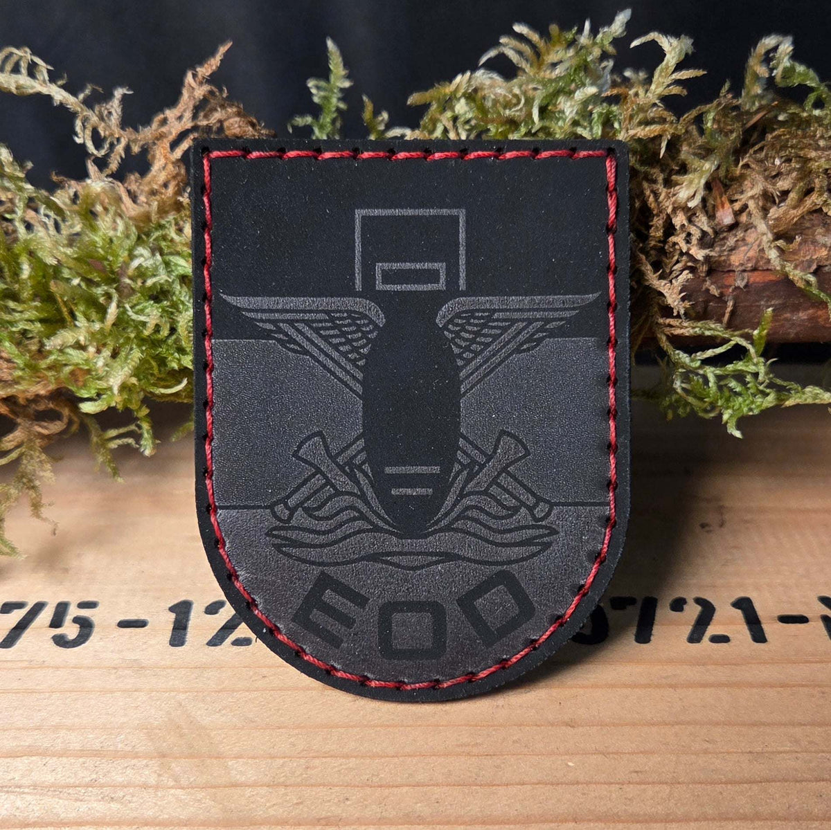 EOD Leder Patch aus schwarzem Echtleder mit feiner Gravur des Bombensymbols und roten Zierstichen