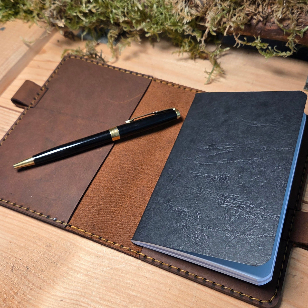 Handgefertigter Premium DIN A6 Organizer aus braunem Leder mit schwarzem Notizbuch und schwarzem Stift mit Goldakzenten