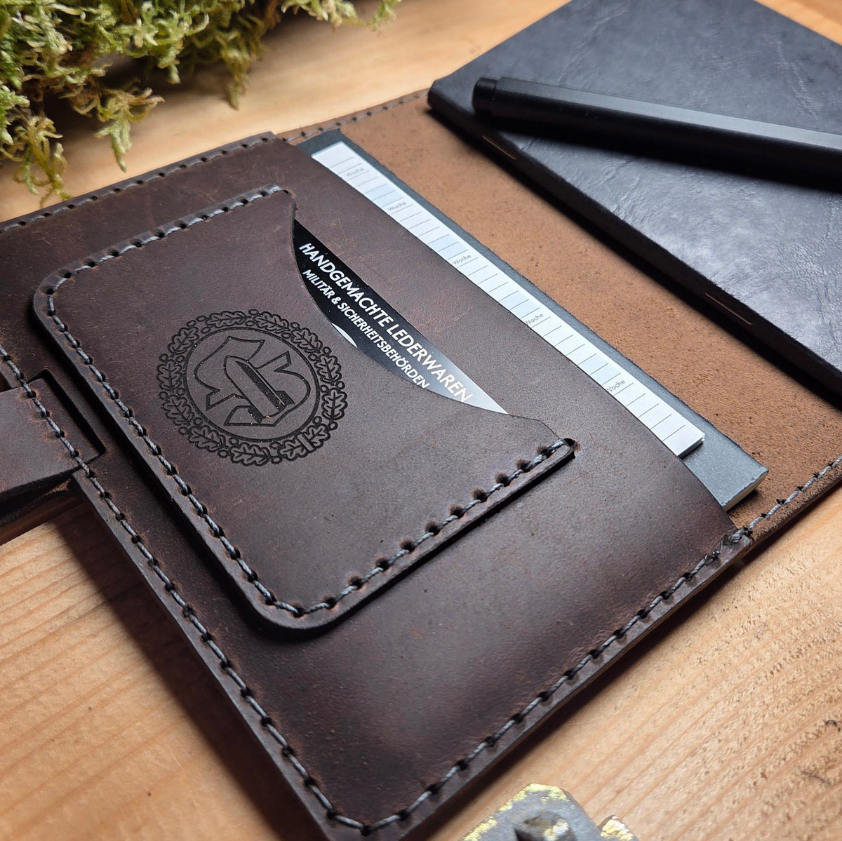 Handgefertigter Premium DIN A6 Organizer aus braunem Leder mit graviertem Wappen, Nahtdetails und Kartenfach innen