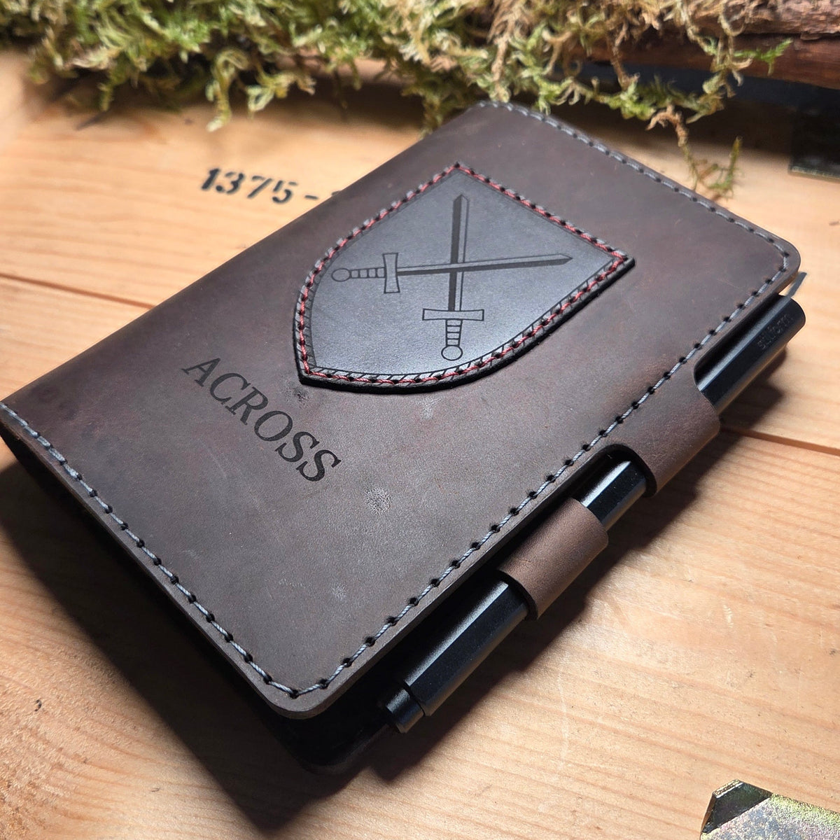 Handgefertigter Premium DIN A6 Organizer aus braunem Leder mit aufgenähtem Wappen, individueller Gravur und Stiftehalter