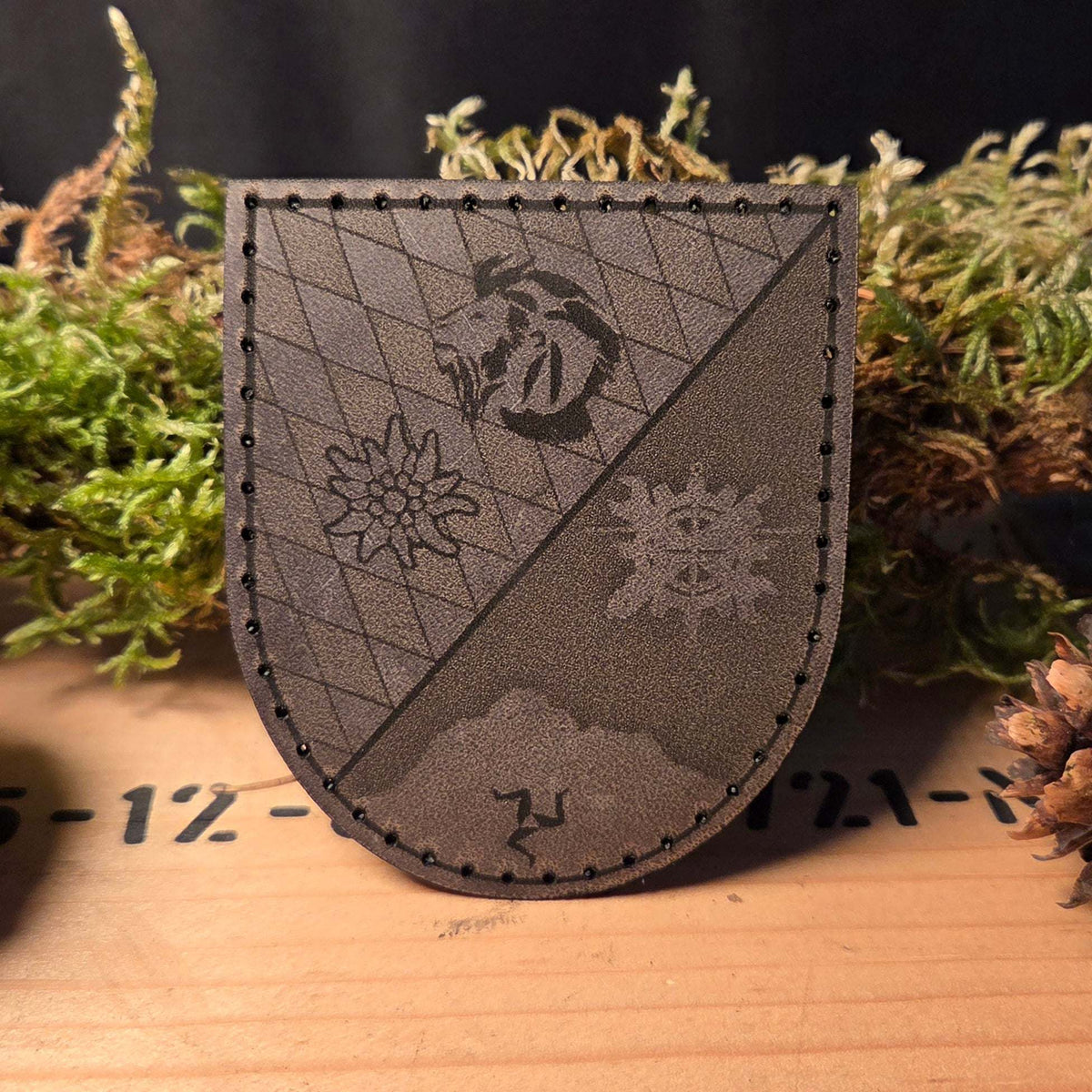 Individueller Leder Patch aus dunkelbraunem Büffelleder mit handvernähter schwarzer Naht und eingraviertem Wappenmuster