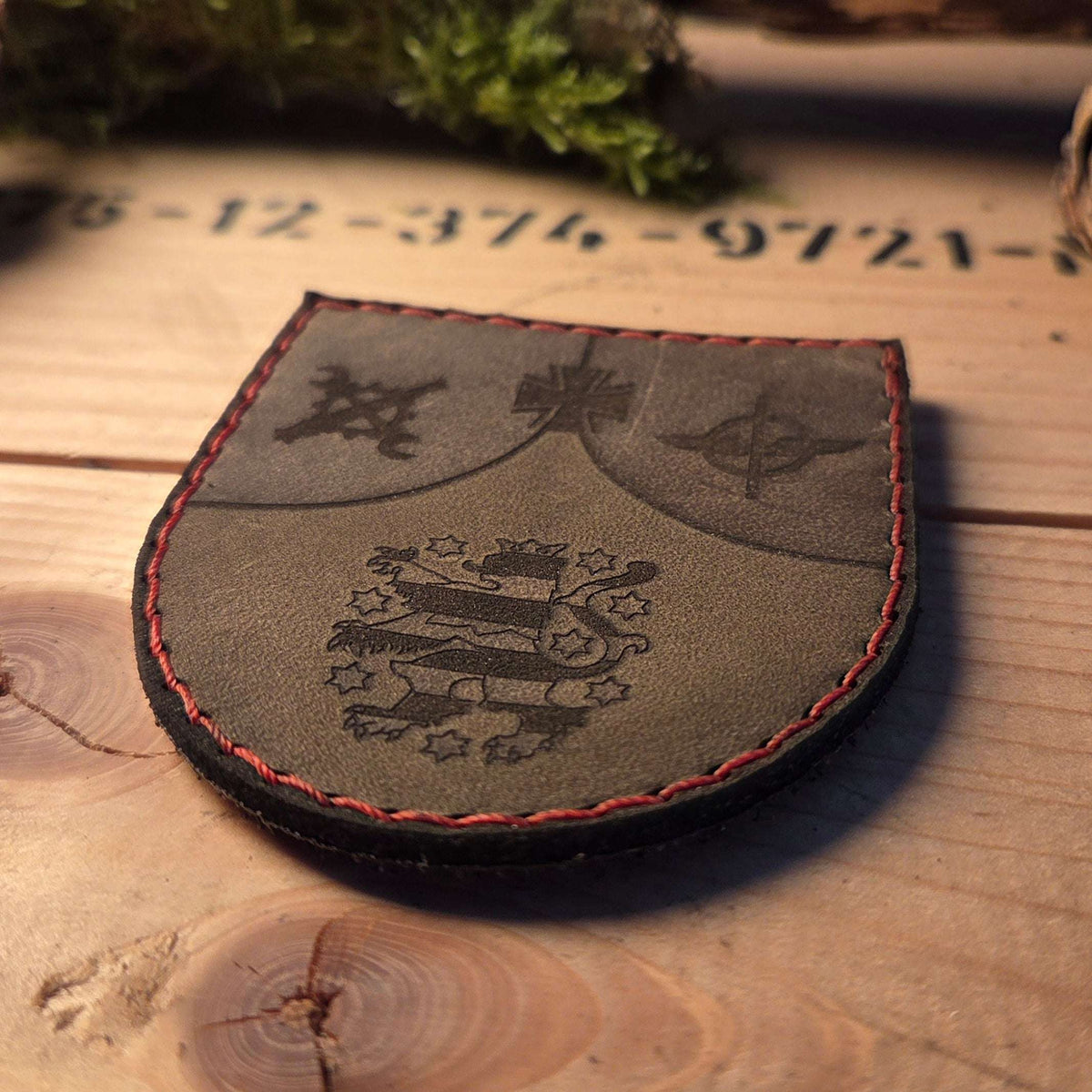Individueller Leder Patch aus braunem Vollnarbenleder mit roter Handnaht und graviertem Wappenmotiv in schwarzer Farbe