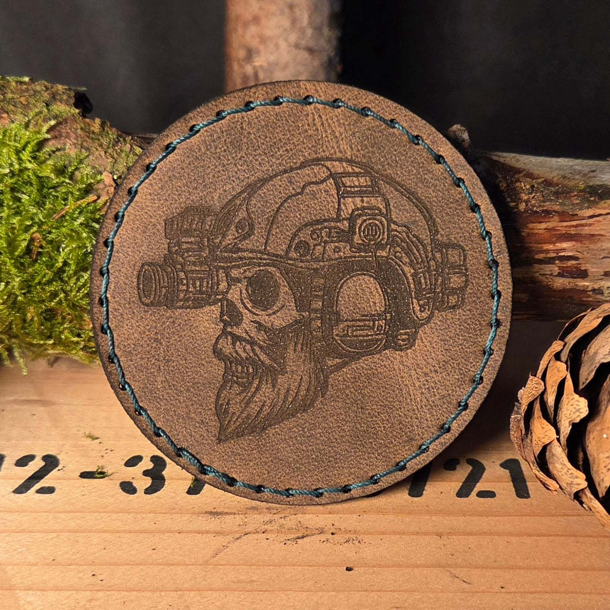 Individueller Leder Patch rund aus braunem Vollnarbenleder mit handgenähter blauer Naht und graviertem Schädel-Motiv mit Helm