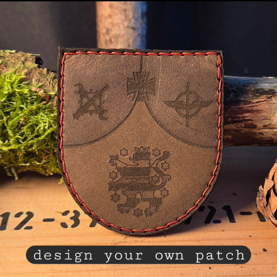 Handvernähter Leder-Patch mit Klett und einer detaillierten Logo-Gravur auf schwarzem Vollnarbenleder.