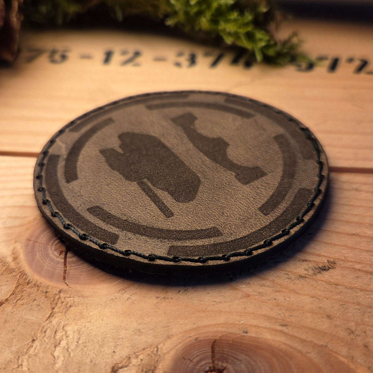Individueller Leder Patch in rundem Design aus braunem Vollnarbenleder mit handgenähter Naht und graviertem Symbol