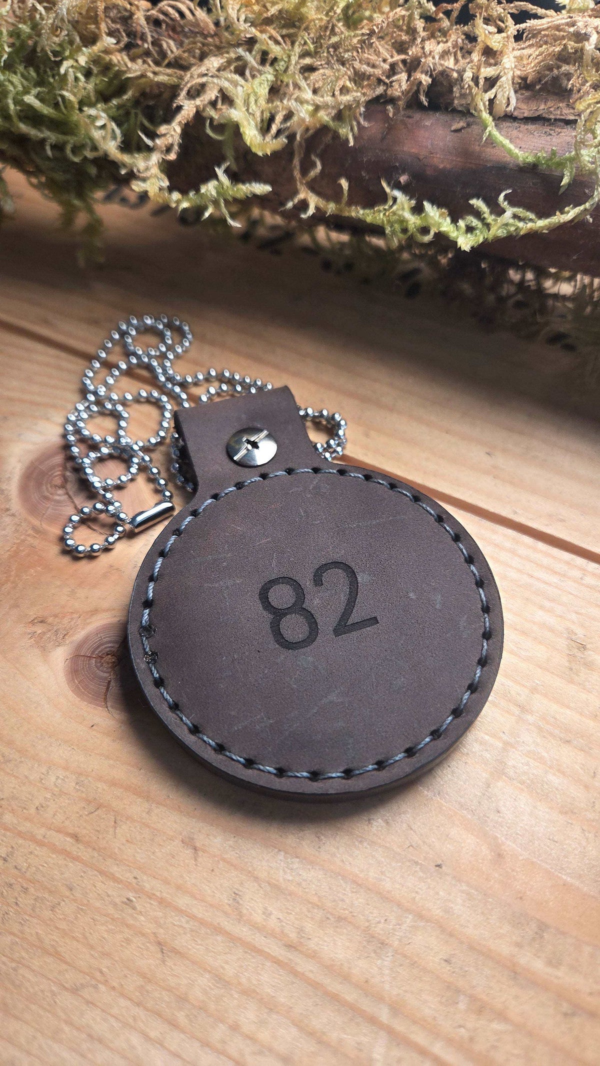 Kettenanhänger aus Leder in Dunkelbraun mit sichtbarer Nummer 82, handvernäht und mit Metallkette