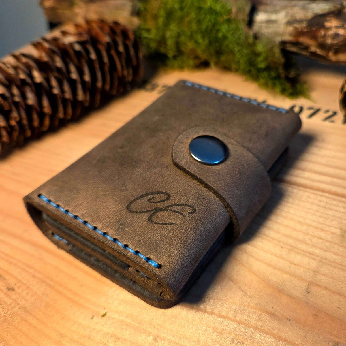 Kompaktes Leder-Wallet aus braunem Vollnarbenleder mit blauer Naht und Druckknopfverschluss, handgefertigt und graviert