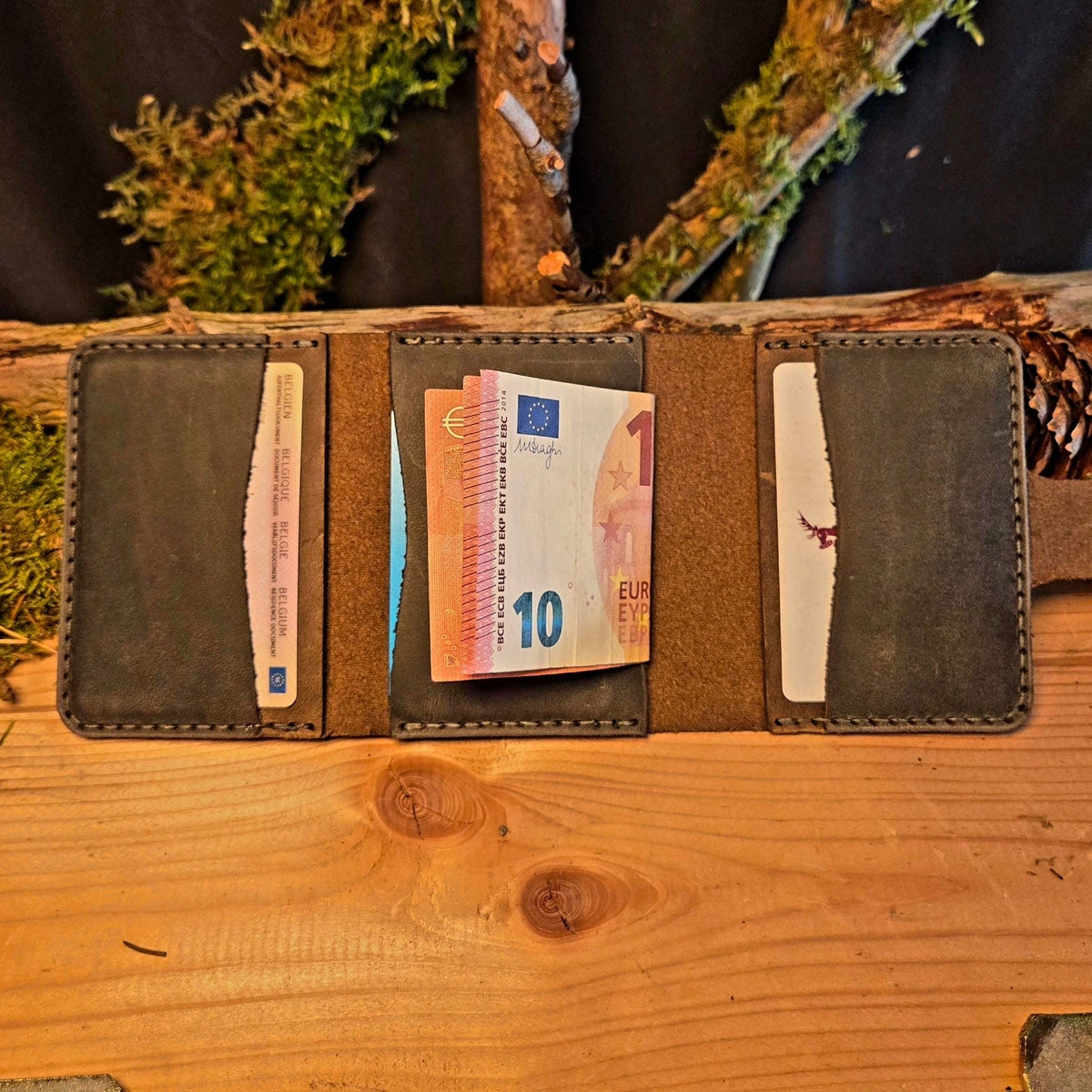 Kompaktes Leder-Wallet aus braunem Nubukleder mit mehreren Fächern, gefüllt mit Euro-Geldscheinen und Karten