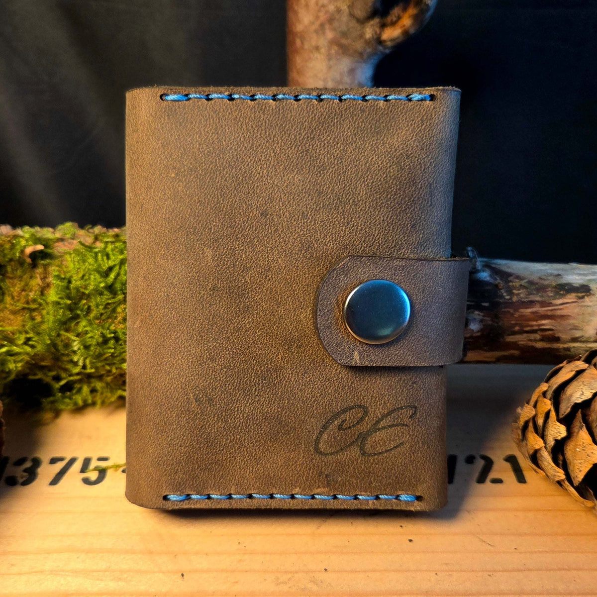 Kompaktes Leder-Wallet aus braunem Vollnarbenleder mit blauen Nähten und Druckknopfverschluss, handgefertigt