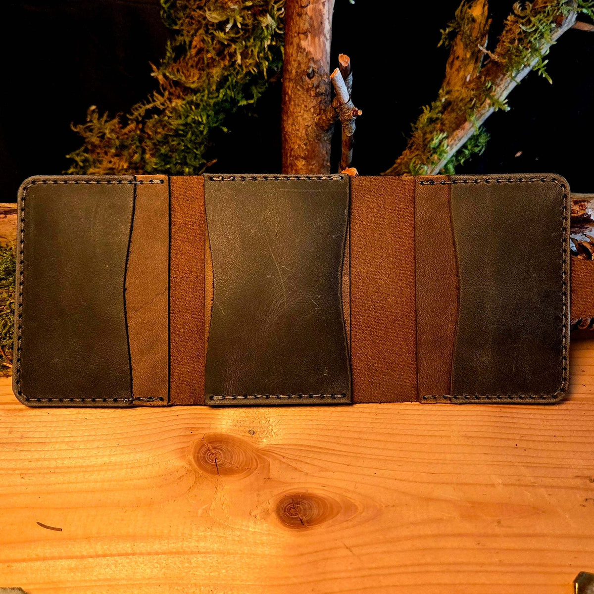 Kompaktes Leder-Wallet aus dunkelbraunem und schwarzem Vollnarbenleder mit mehreren Steckfächern und Handnaht