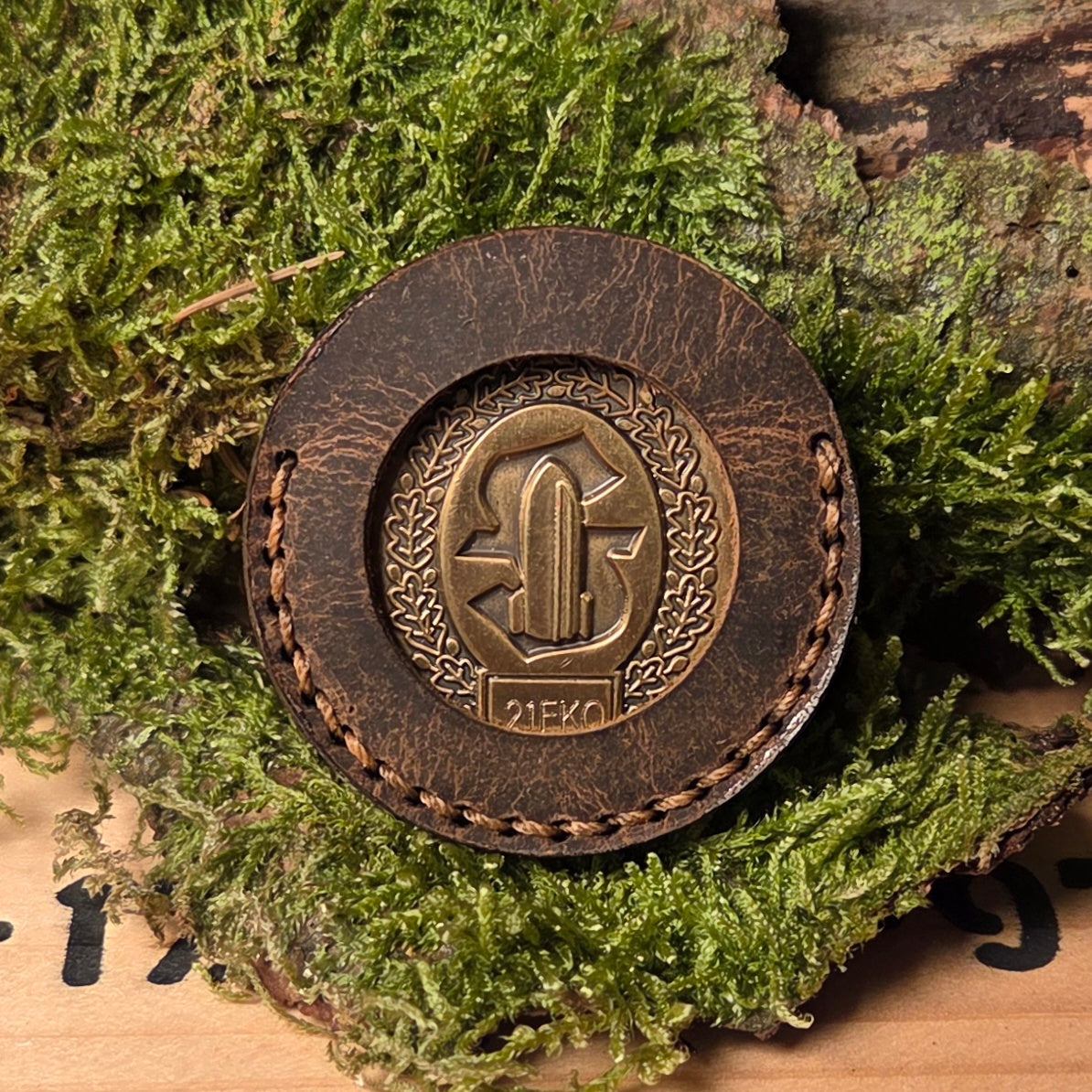 Leder Coinhülle aus braunem Vollnarbenleder mit handvernähtem Rand und eingelassener goldener Münze