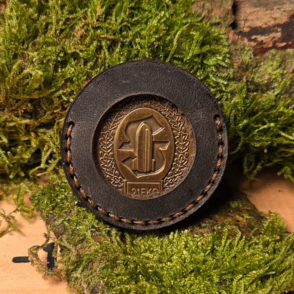 Runde Leder Coinhülle in schwarzem Vollnarbenleder mit handvernähter Umrandung und sichtbarer Münzprägung in der Mitte