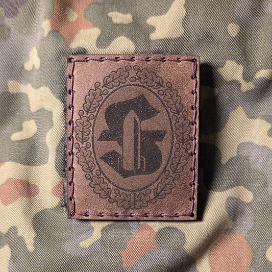 Sonderabzeichen der Bundeswehr Feuerwerker graviert auf braunem Leder und von Hand auf Klett aufgenäht.