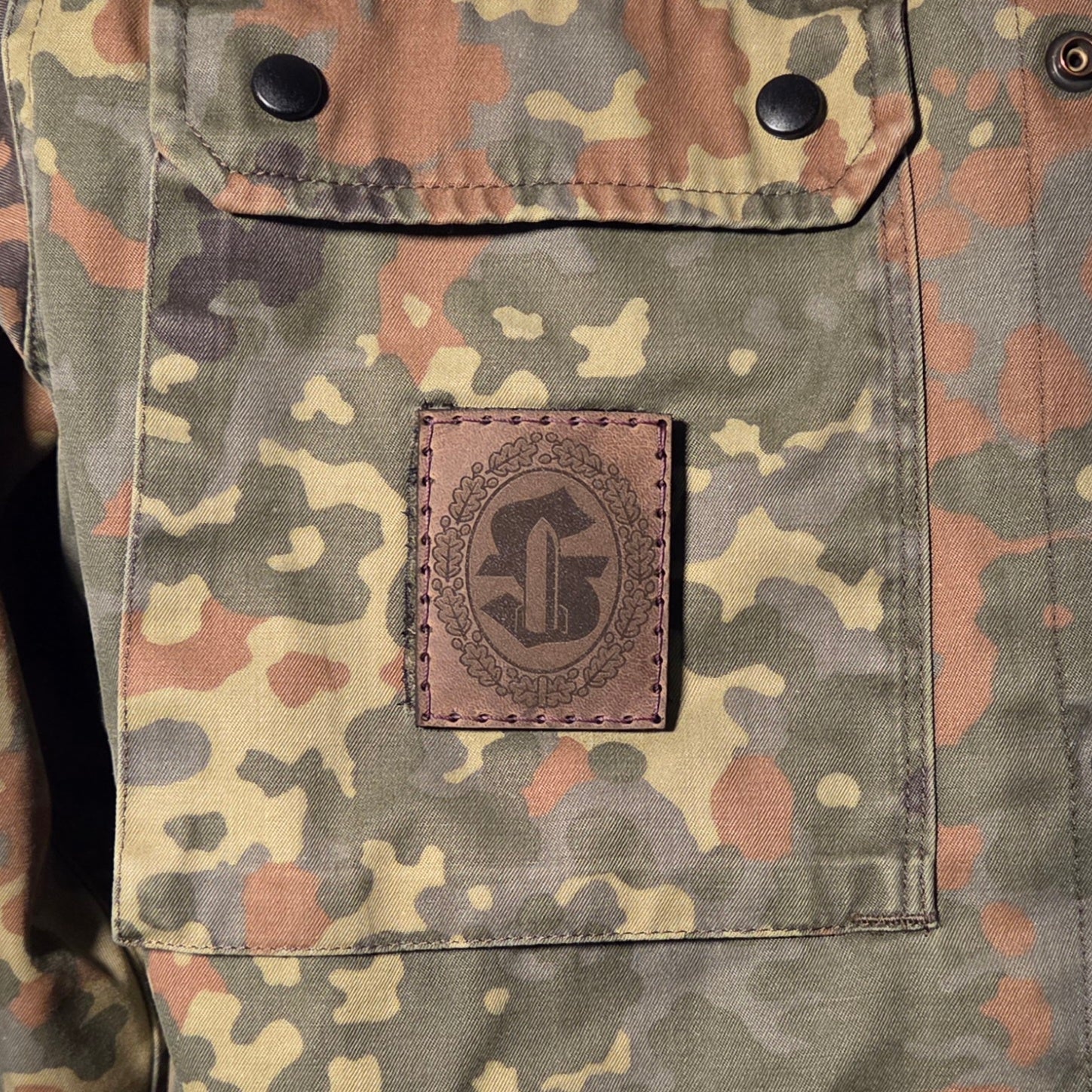 Sonderabzeichen der Bundeswehr Feuerwerker graviert auf braunem Leder und von Hand auf Klett aufgenäht.