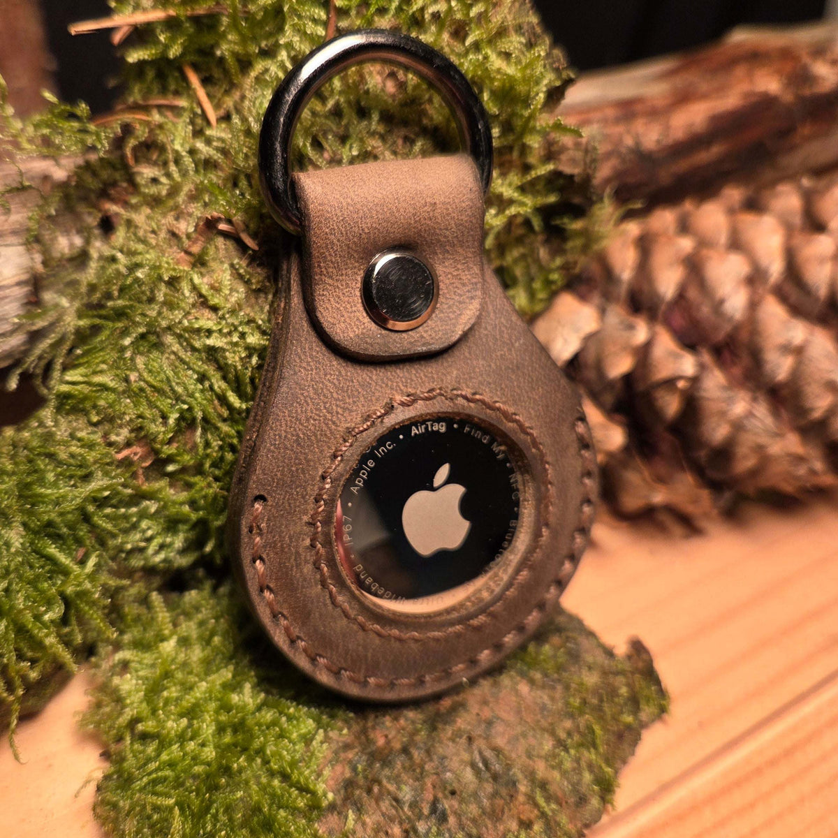 Lederanhänger für Apple Air Tag aus braunem Büffelleder mit sichtbarer Rundnaht, Metallring und Apfel-Logo