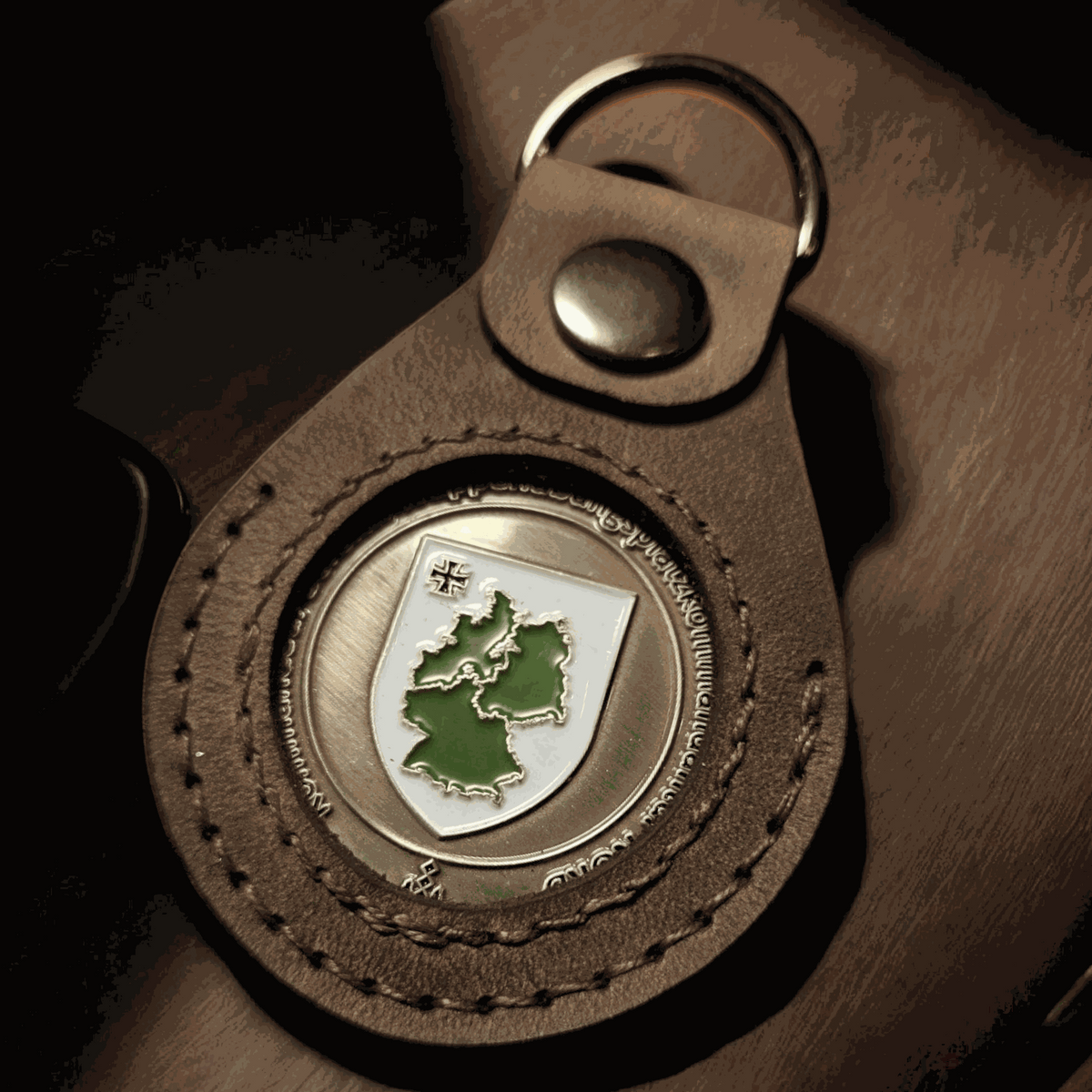Lederanhänger für Challenge Coin aus braunem Echtleder mit Edelstahl-D-Ring und sichtbarem Coin mit Deutschlandkarte