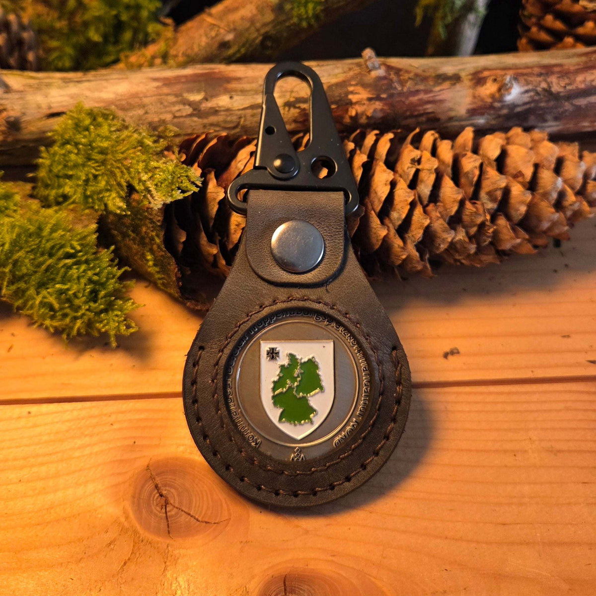 Lederanhänger für Challenge Coin aus braunem Echtleder mit sichtbarem Coin und schwarzem Karabiner zur Befestigung