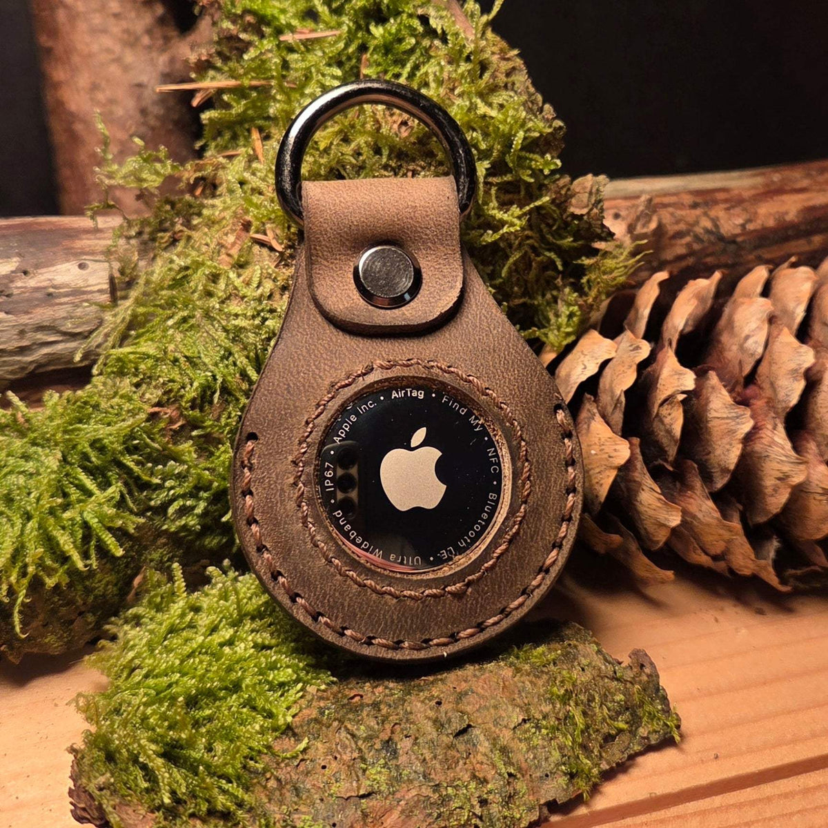 Lederanhänger für Apple Air Tag aus braunem Büffelleder mit handgenähter Ziernaht und Metallring für Befestigung