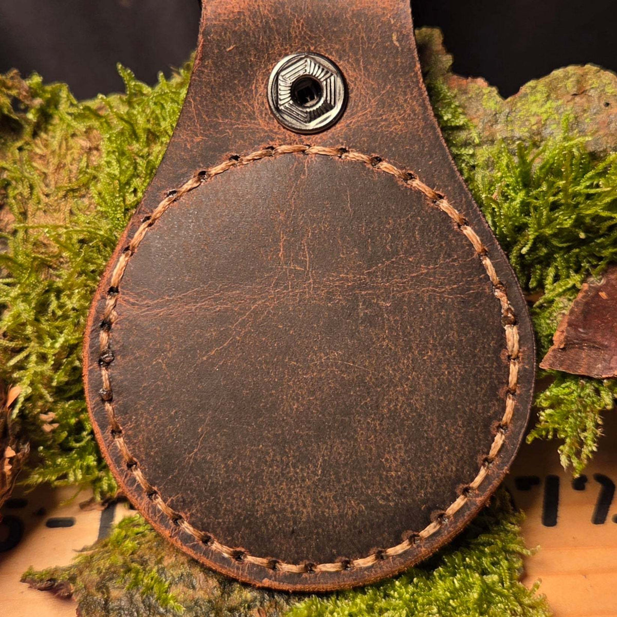 Rund geformter Lederanhänger für Challenge Coin aus robustem braunem Rindsleder mit sichtbarem Nahtmuster und Metallniete
