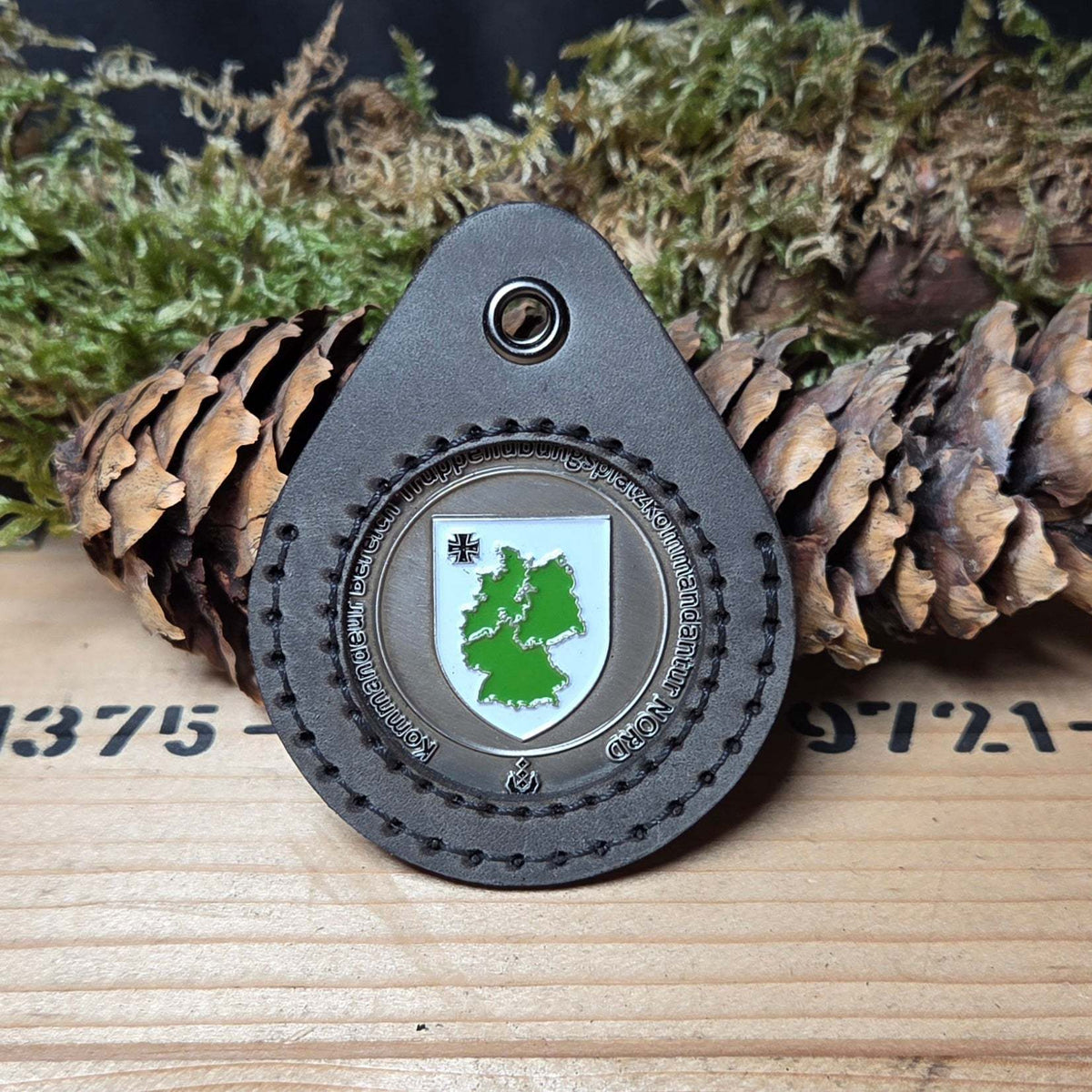 Schlüsselanhänger aus Leder in dunkelbrauner Farbe mit handgenähter Naht und einem Challenge Coin mit Deutschlandkarte in Grün