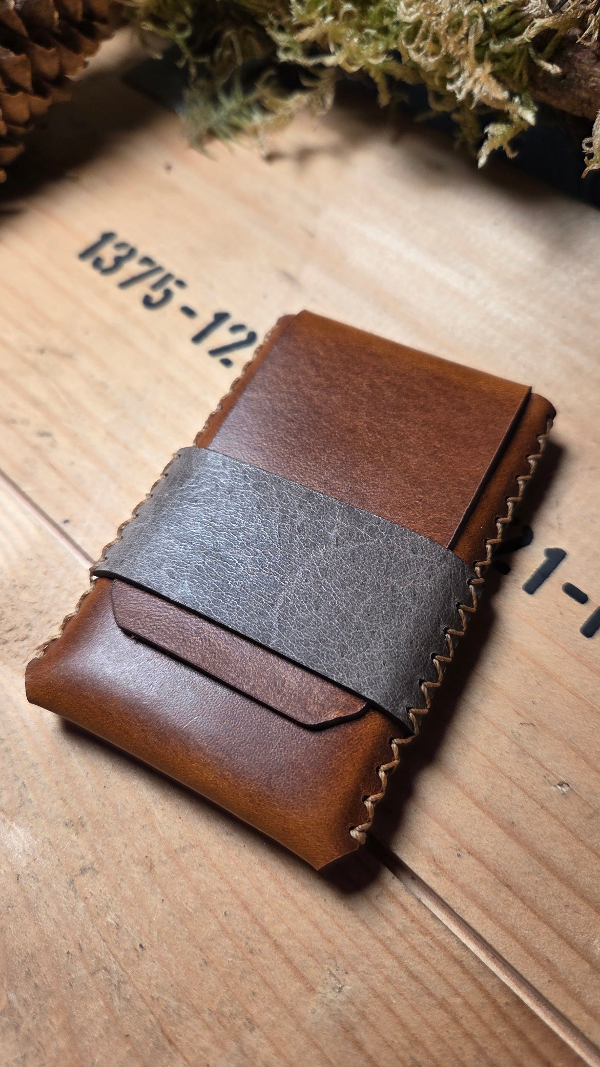 Handgefertigtes Slim Wallet aus Leder in braun mit grauem Lederband und sichtbaren handgenähten Nähten aus hochwertigem Material